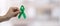 Man holding green Ribbon for supporting people living and illness. Liver, Gallbladders bile duct, kidney Cancer and Lymphoma