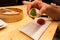 Man holding a green tea biten big mochi on a plate on a wooden table in an asian restaurant or chinese dumplings. bar. Green