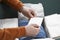 Man holding greeting card near parcel with Christmas gift, closeup