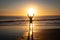 Man holding hands in air at sunset view over ocean from beach