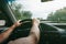 Man is holding hands on the car`s steering wheel. Raindrops on the windscreen. Guy is traveling in the bad weather. Dangerous