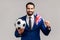 Man holding hands flag of United Kingdom and football ball supporting favourite team on championship