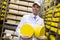 Man holding a head of cheese at a dairy plant