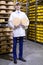 Man holding a head of cheese at a dairy plant