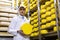 Man holding a head of cheese at a dairy plant