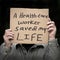 Man holding health care worker saved my life homemade sign