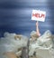 Man holding Help! sign in giant pile of recyclable containers products representing environmental challenges