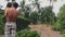 Man holding his little girl in his arms and looking at the flooded village road