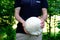 Man holding a huge white mushroom Calvatia gigantea in his hands, foliage of green trees in the background, forest, nature wonders