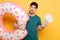 Man holding inflatable donut and little