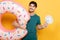 Man holding inflatable donut and little