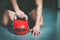 Man holding kettle bell with his hand on the gym floor.