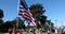 Man holding a large American Flag an a patriotic freedom rally in Beverly Gardens Park