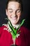 Man holding lily of valley and smiling at camera