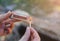 Man is holding matches in hands. Person is making fire outdoors