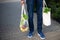 Man is holding mesh shopping bag with begetables without plastic bags at farmers market. Zero waste, plastic free concept.