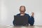 A man holding a mug in front of a laptop