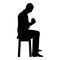 Man holding mug and looking at the contents inside while sitting on stool Concept of calm and home comfort icon black color