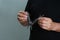 Man holding multitool on grey background, closeup