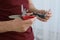 Man holding multitool on light background, closeup