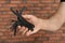 Man holding multitool near brick wall, closeup