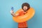 Man holding orange rubber ring and mobile phone, having video call, sending air kisses.