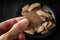 Man holding a piece of cacao paste in his hand