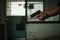 Man holding a pistol, standing in a room in black, pointing and aiming a gun at a target. concept of assassination, murder,