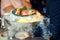 Man holding a plate of seafood in a smoke - oysters, shrimps, sushi.