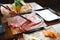 Man holding rare slice Wagyu A5 beef by chopsticks for boiling in Shabu hot pot