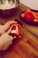 Man holding red, sweet pepper or paprika. Health and healthy lifesyle concept. Man cuts a red bell pepper with a knife to obtain