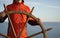 Man holding ship rudder with sea on background