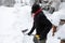 Man holding shovel while shoveling snow.