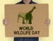 Man holding a sign with World Wildlife Day