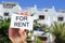 Man holding a signboard with the text for rent