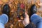 Man holding smartphone with Happy Thanksgiving photo message on the screen outdoors in park full of autumn leaves on the ground