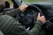 Man holding steering wheel in car, closeup. Driving test