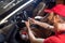 Man holding steering wheel crouched near car