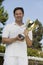 Man Holding Tennis Trophy net on tennis court