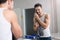 Man holding towel in bathroom