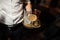 Man is holding a tray with one empty glasse and with two alcoholic cocktails- sour mix and negroni