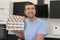 Man holding two pizza boxes at home