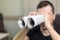 Man holding two twisted roll newspaper. Metaphor or allegory with binoculars. Selective focus on newspapers