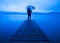Man Holding Umbrella on a Jetty Tranquil Lake Concept