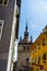 a man holding an umbrella looking up at a building with a spire