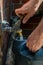 A man holding a watering can underneath an outside tap, during a drought and hosepipe ban in the UK