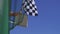 Man holding and waving Checkered race flag at finish line on a raceway.
