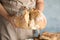 Man holding whole wheat bread on color background