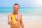 Man holding yellow sunscreen bottle on the beach