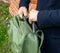 A man holds a bag by the handle and takes out a laptop. Universal city sports bag in khaki color.